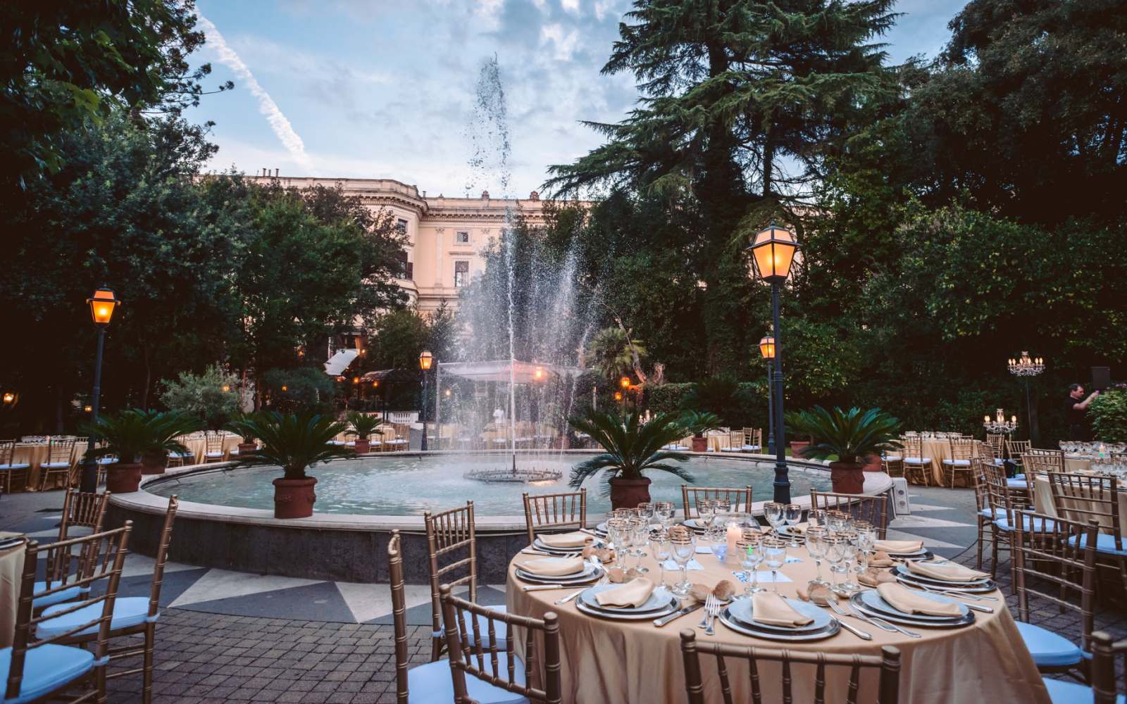 esterno palazzo brancaccio a roma con tavoli rotorndi allestiti per cerimonia, sullo sfondo una fontana accesa