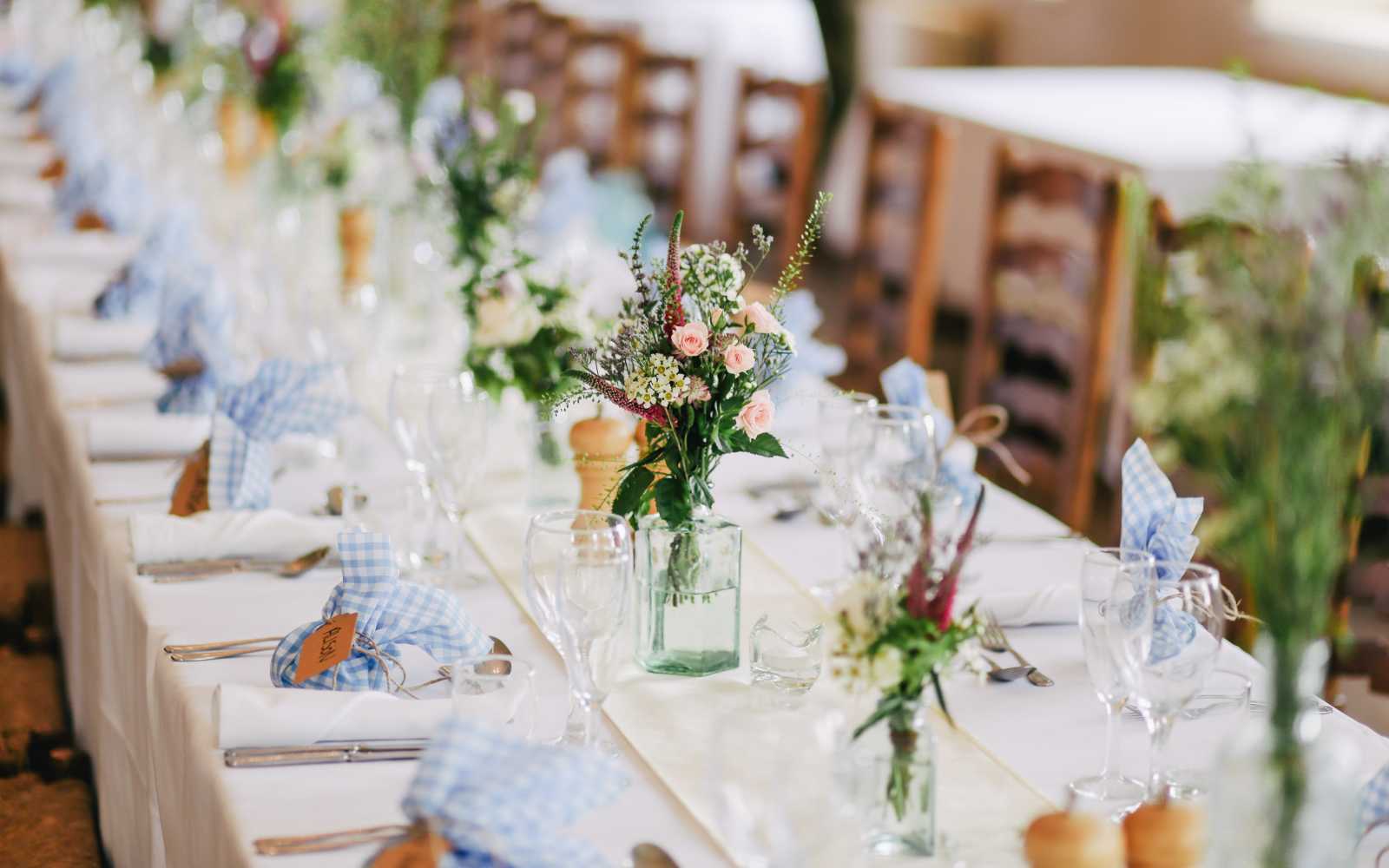 tavola imbandita con fiori freschi e tovaglia bianca per un matrimonio stile country
